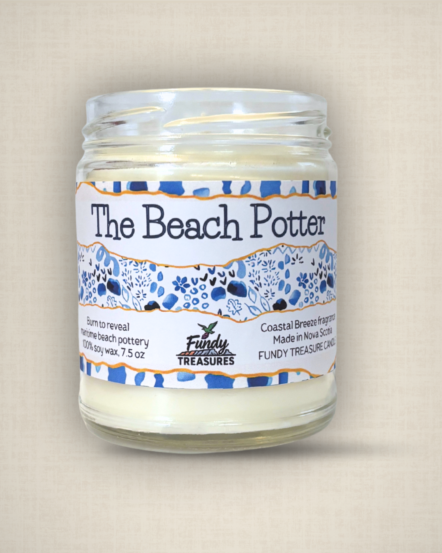 a coastal Nova Scotia candle with a piece of beach pottery inside